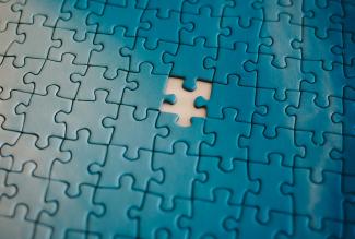 A piece of a puzzle with a missing piece by Tanja Tepavac courtesy of Unsplash.