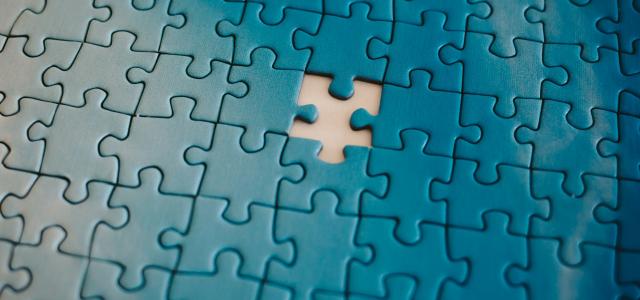 A piece of a puzzle with a missing piece by Tanja Tepavac courtesy of Unsplash.